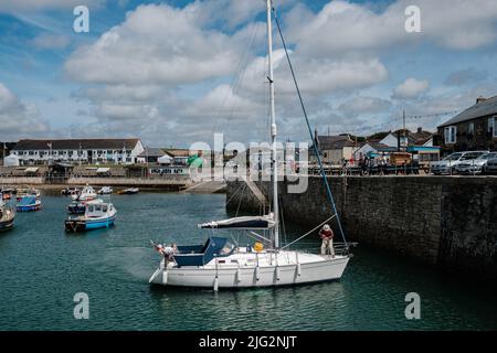 Uno yacht in visita ormeggio nel porto interno di Porthleven, Cornovaglia Foto Stock