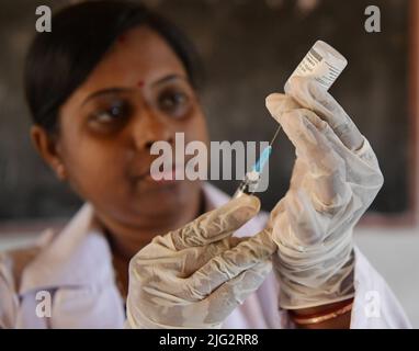 Un operatore medico si prepara ad inoculare uno studente con il vaccino preventivo Corbevax Covid-19 in una scuola di Agartala. Tripura, India. Foto Stock