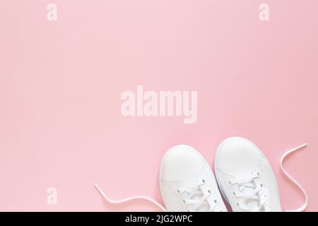 Tutte le sneaker bianche su sfondo rosa. Vista dall'alto, disposizione piatta Foto Stock