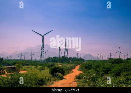 Bella vista di mulini a vento o turbine a vento fattoria a Nagercoil, India del Sud. Con un cielo colorato e montagne come sfondo. Foto Stock