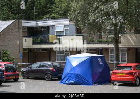 Millthorpe Close, Ward End, Birmingham, Inghilterra, 7 luglio 2022. La polizia delle West Midlands ha cordonato gli appartamenti a Millthorpe Close, Birmingham, dopo che si è verificato un incidente. I detective sono stati visti fare domande porta a porta, mentre una ford EcoSport blu era parcheggiata sotto una tenda forense della polizia. Fig. Per credito: Interrompi stampa Media/Alamy Live News Foto Stock