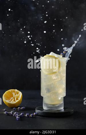 Spruzzata di limonata di lavanda fresca in vetro su sfondo nero. Formato verticale. Bevande estive. Foto Stock