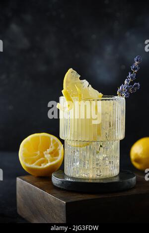 Limonata di lavanda frizzante in vetro su sfondo nero. Bevande fresche estive. Foto Stock