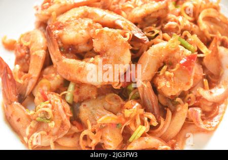 Gamberetti bolliti piccanti e aciditi con fette di limone grassetta Thai insalata sul piatto Foto Stock