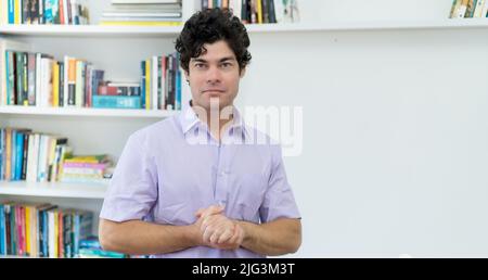 Bell'uomo d'affari caucasico con capelli neri in ufficio Foto Stock