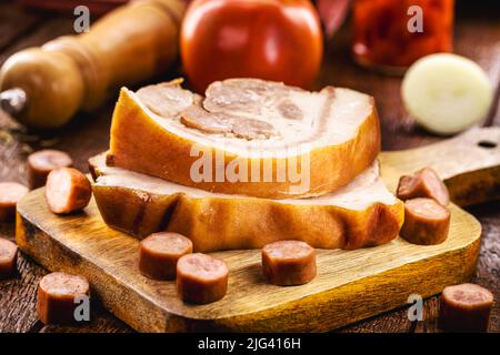 fette di pancetta cruda e salsiccia di maiale, carne di maiale su tavola di legno, maiale dal brasile Foto Stock
