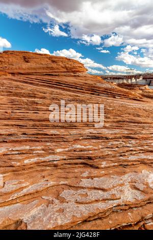 Grande parete rocciosa a motivi geometrici con la diga del Glenn Canyon sullo sfondo, The Chains, Page, Arizona, USA Foto Stock
