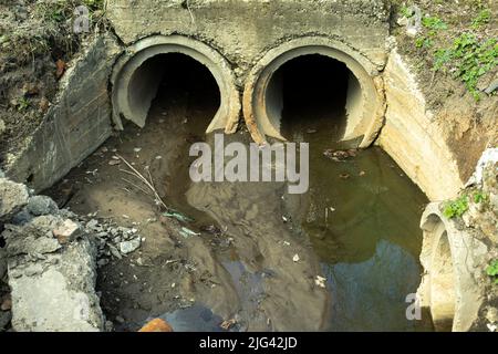 I tubi scaricano i rifiuti. Fognatura in città. Tubi di calcestruzzo in terra. Sistema di smaltimento dei rifiuti. Foto Stock