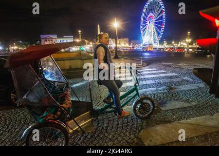 14-05-2016 PARIGI, Francia. Una giovane donna - un risciò, di aspetto europeo, e una ruota Ferris di notte e pietre di pavimentazione e Place de la Concor Foto Stock