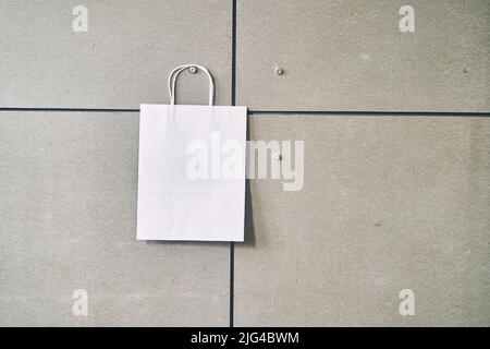 Sacchetto monouso in carta bianca su sfondo grigio Foto Stock