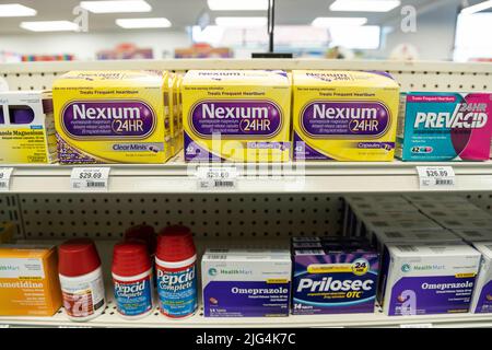 Scatole di Nexium, Prilosec, e Pepcid marchio heartburn farmaco siedono sugli scaffali di un negozio di droga Foto Stock