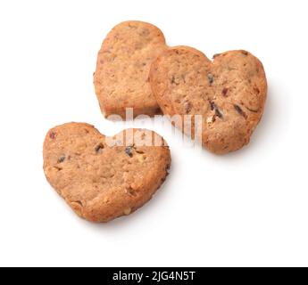 Tre biscotti di cuore fatti in casa con noci e uva passa isolati su bianco Foto Stock