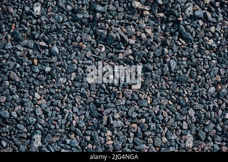 Grigio piccole rocce terra texture strada nera pietra sfondo ghiaia ciottoli Foto Stock
