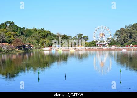 Lago con ruota Ferris sullo sfondo in primo piano bandiere del Brasile, con bandiere del Brasile e pedalò, Brasile, Sud America, selettivo fo Foto Stock