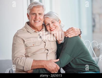 Felice coppia caucasica senior bonding a casa. Marito e moglie maturi abbracciano mentre si rilassano insieme. Uomo e donna felici e allegri in un amore Foto Stock
