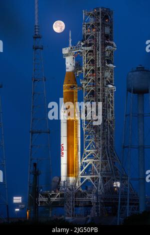 Una luna piena sorge sul razzo della NASA Artemis i Space Launch System con la navicella spaziale Orion a bordo di un lanciatore mobile al Launch Complex 39B, presso il Kennedy Space Center, 14 giugno 2022, a Cape Canaveral, Florida. SLS e Orion sono in fase di preparazione per una prova di vestito umido per mettere in pratica le tempistiche e le procedure di lancio. Foto Stock