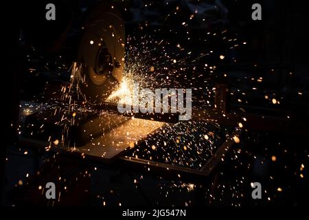 Scintille di metallo. Molte scintille dall'acciaio per smerigliatura. La sega circolare taglia il metallo. Foto Stock