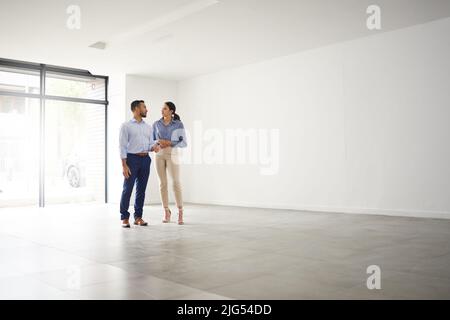 Benvenuti a casa è il posto perfetto per voi. Shot di un giovane agente immobiliare maschile che mostra ad un cliente una casa. Foto Stock