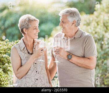 Vino e cena. Scatto di una coppia matura godendo un bicchiere di vino all'aperto. Foto Stock