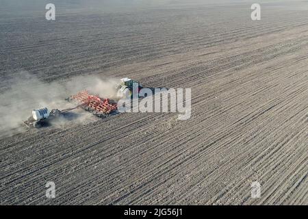 Trattore con macchine agricole trainate per l'aratura e l'applicazione di fertilizzanti Foto Stock