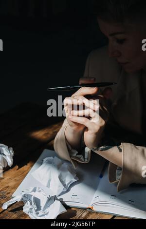 Burnout, problemi emotivi, concetto di depressione. Triste stanca depressa donna sdraiata sul tavolo tra carte Foto Stock