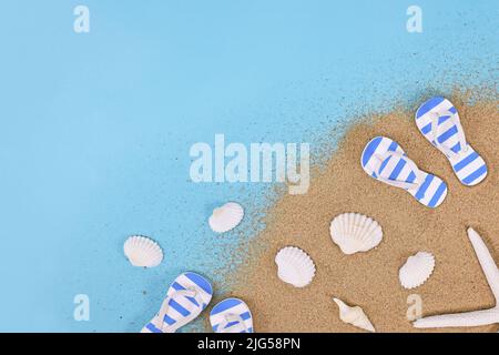 Scarpe estive, conchiglie, stelle marine e sabbia in un angolo di sfondo blu Foto Stock