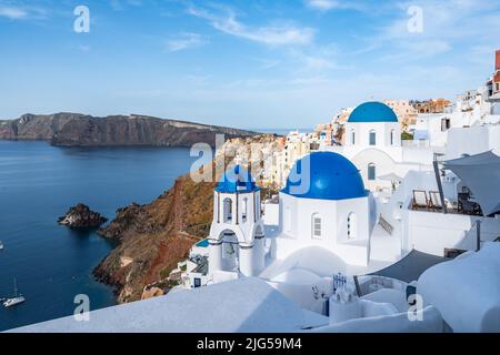 Vista di Oia a Santorini, il villaggio più famoso dell'isola con le tipiche case bianche e le chiese a cupola blu Foto Stock