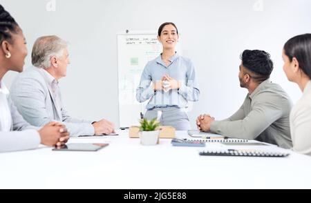 Sessione di strategia in corso. Scatto corto di una giovane donna d'affari attraente che dà una presentazione nella sala del consiglio. Foto Stock