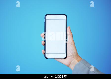 Ogni uomo d'affari di successo ha bisogno di questa app. Studio girato di una donna d'affari irriconoscibile mostrando il suo schermo del cellulare alla fotocamera mentre Foto Stock
