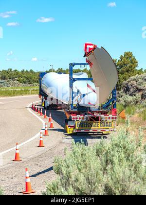 Singola pala di turbina eolica lunga su un camion che si trova in un'area di riposo nello stato dell'Idaho. Foto Stock