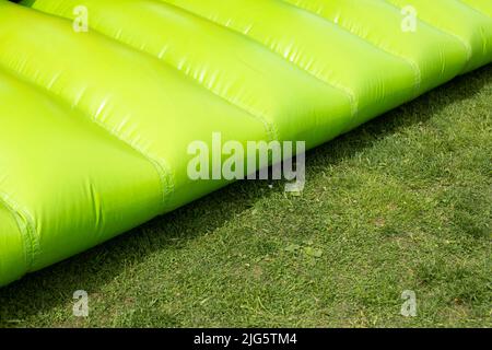 Design gonfiabile. Trampolino per saltare. Materiale verde. Air tre disegni. Area per bambini. La barra di ostacolo è nei dettagli. Foto Stock