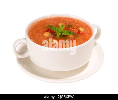 Tradizionale zuppa spagnola di gazpacho freddo in tazze di brodo e piattino isolato su sfondo bianco Foto Stock