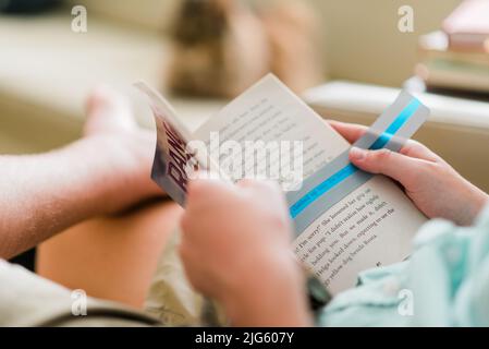 Lettura del bambino dislessico con sovrapposizione di colore dislessia nel suo libro. Una sovrapposizione di colore verde sulla pagina facilita la lettura. Foto Stock