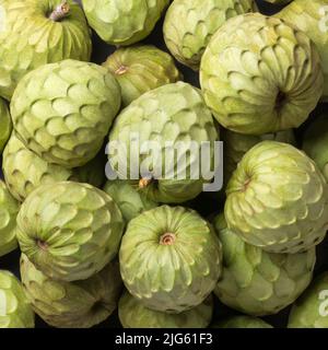 cherimoya, annona cherimoya, frutta commestibile a forma di cono conosciuta anche come mela crema o mela zucchero, mucchio di frutta tropicale dal gusto dolce preso dall'alto Foto Stock