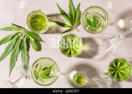 SBD canapa bere in vari bicchieri, fondo di cemento chiaro ombra dura, cocktail di energia cannabis Foto Stock