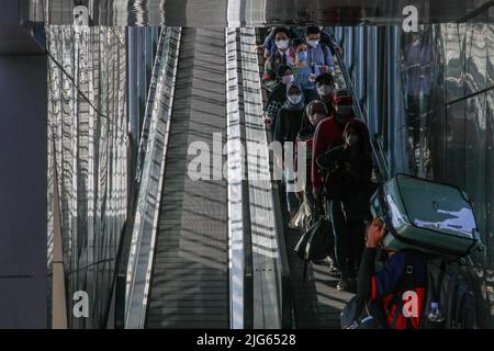 Bandung, Indonesia. 08th luglio 2022. I passeggeri che indossano maschere facciali camminano verso il treno alla stazione ferroviaria di Bandung. Il governo indonesiano implementerà un vaccino di richiamo per il Covid-19 nelle prossime due settimane come requisito per i viaggiatori. Credit: SOPA Images Limited/Alamy Live News Foto Stock