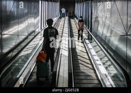 Bandung, Indonesia. 08th luglio 2022. I passeggeri che indossano maschere facciali camminano verso il treno alla stazione ferroviaria di Bandung. Il governo indonesiano implementerà un vaccino di richiamo per il Covid-19 nelle prossime due settimane come requisito per i viaggiatori. Credit: SOPA Images Limited/Alamy Live News Foto Stock