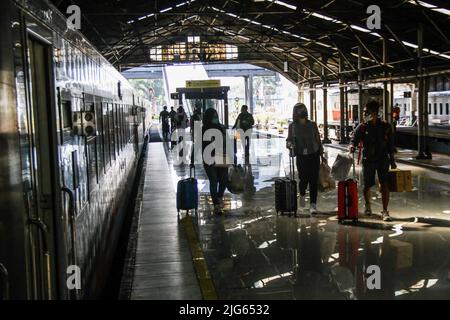 Bandung, Indonesia. 08th luglio 2022. I passeggeri che indossano maschere facciali camminano verso il treno alla stazione ferroviaria di Bandung. Il governo indonesiano implementerà un vaccino di richiamo per il Covid-19 nelle prossime due settimane come requisito per i viaggiatori. Credit: SOPA Images Limited/Alamy Live News Foto Stock