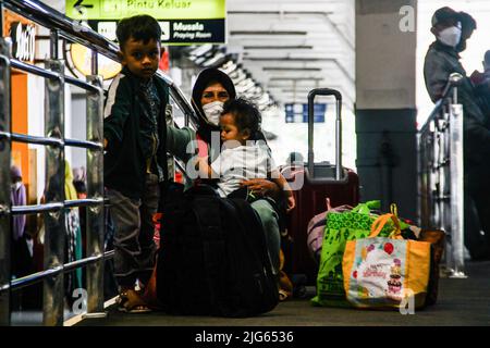 Bandung, Indonesia. 08th luglio 2022. Una donna con i suoi figli ha visto aspettare il treno alla stazione ferroviaria di Bandung. Il governo indonesiano implementerà un vaccino di richiamo per il Covid-19 nelle prossime due settimane come requisito per i viaggiatori. Credit: SOPA Images Limited/Alamy Live News Foto Stock