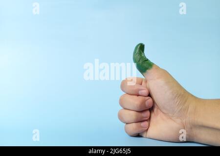 Pollice verde e concetto ambientalista. Pollice umano su dipinto con colore verde. Foto Stock