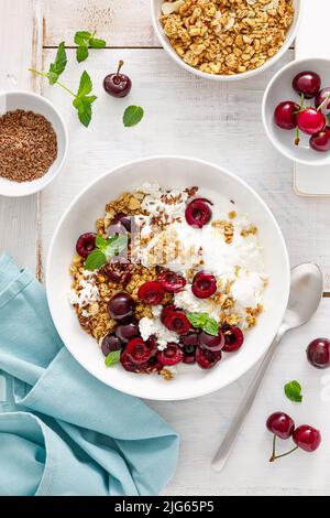 Granola di ciliegia acidita con formaggio caserario e yogurt. Cibo sano, colazione dietetica Foto Stock