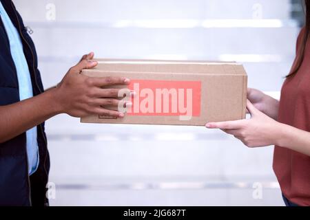 La consegna è arrivata. Colpo di una donna che accetta la sua consegna dall'uomo di consegna. Foto Stock