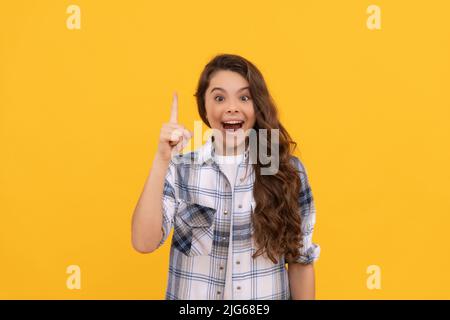 bambino ispirato in maglia a scacchi con capelli ricci lunghi su sfondo giallo Foto Stock