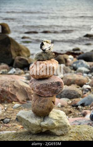 Una piramide di pietra su una spiaggia sassosa Foto Stock