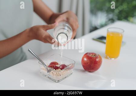 La giovane donna prepara una colazione a basso contenuto calorico su prescrizione medica Foto Stock