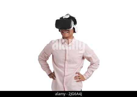 Giovane uomo peruviano ridendo indossando cuffie per realtà virtuale, isolato. Foto Stock