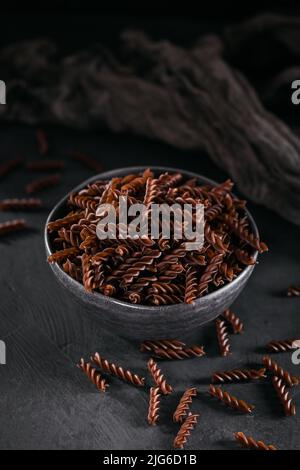 Pasta biologica non cotta di grano saraceno Fusilli su sfondo scuro Foto Stock