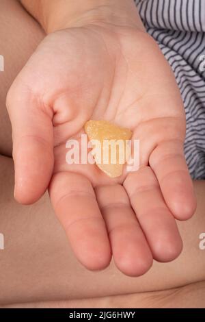 Ragazza che tiene un pezzo di cera con un alto contenuto di THC nelle sue mani. Foto Stock