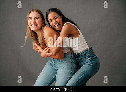 Due amiche sorridenti e ridenti che giocano e si divertono Foto Stock