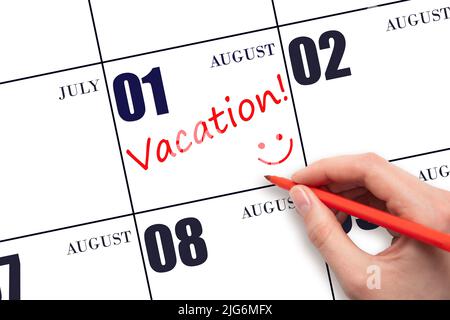 1st agosto. Una mano che scrive un testo DI VACANZA e che disegna un volto sorridente su una data di calendario 1 agosto. Concetto di pianificazione delle vacanze. Estate mese, giorno Foto Stock